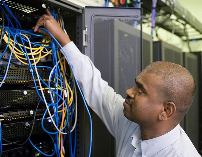 A man working on wires in an office.