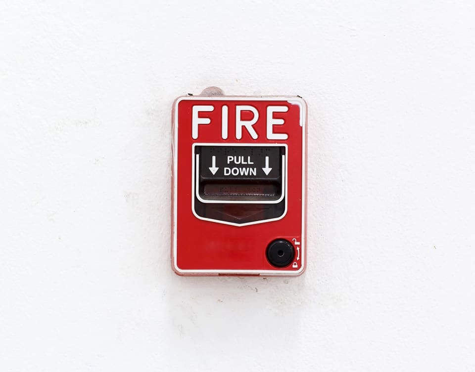 A fire alarm on the wall of a building.